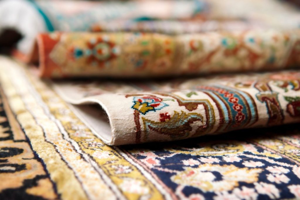 Close-up of various carpet types, showcasing textures and colors, with a focus on water-damaged areas.