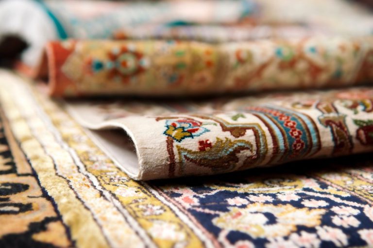 Close-up of various carpet types, showcasing textures and colors, with a focus on water-damaged areas.